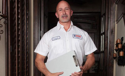 Technician standing with clipboard in hand