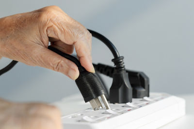 Hand plugging plug into surge protector