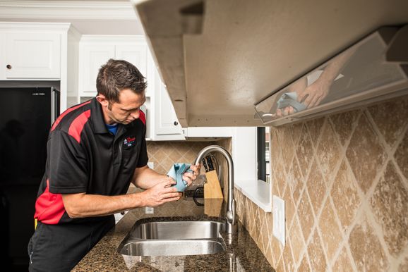 Plumber inspecting water flowing from faucet