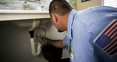 A plumber inspecting a clogged drain in a Florida home
