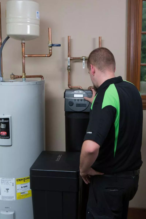 Plumber inspecting a water softener - Mr. Plumber by Metzler & Hallam