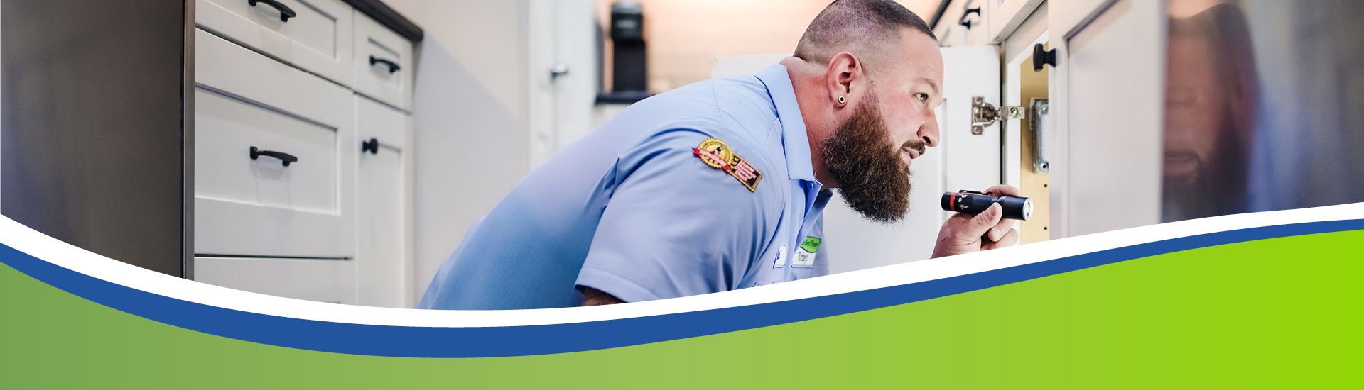 Plumber inspecting under sink