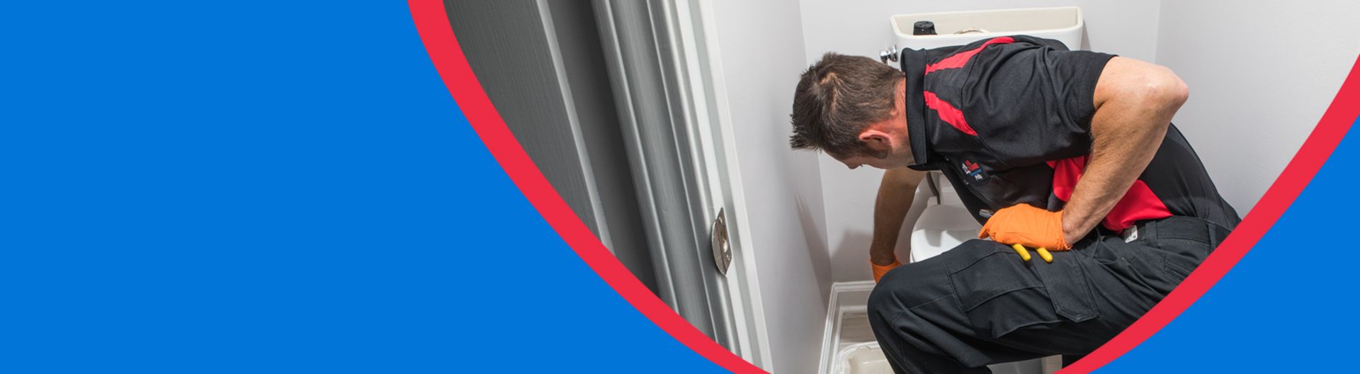 A plumber repairing a toilet in an Atlanta area home