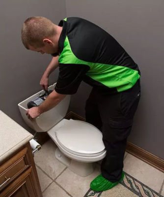 Plumber Performs Maintenance on Toilet Tank