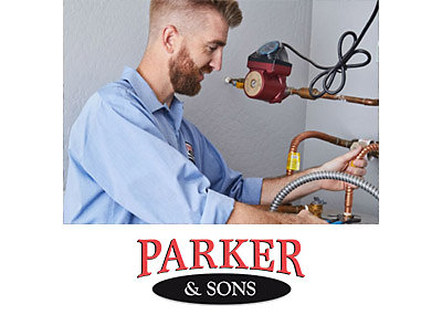A plumber repairing a water heater in a Scottsdale home