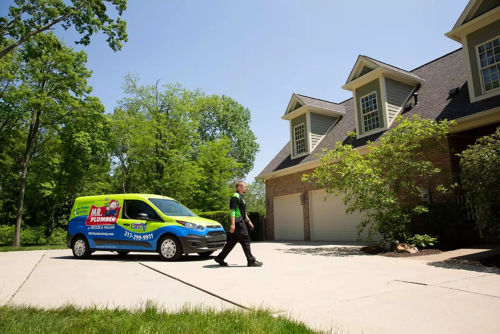 Plumber walks in front of Mr. Plumber truck