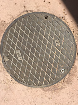 A round metal cover on the ground