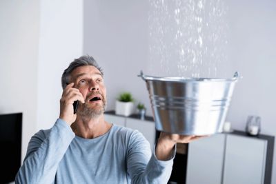 Man holding bucket under leak