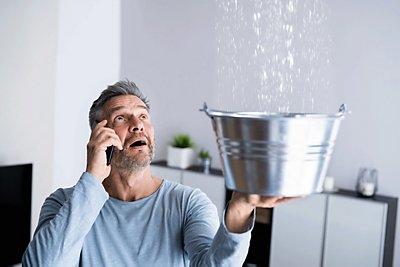 Man holding bucket under leak
