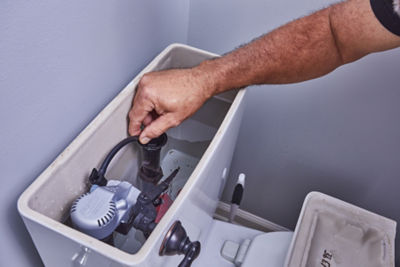 Plumber inspecting a toilet that sounds like it's running