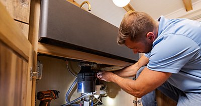 Technician doing repair in kitchen