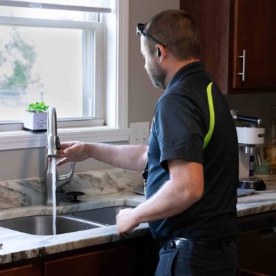 plumber at kitchen sink