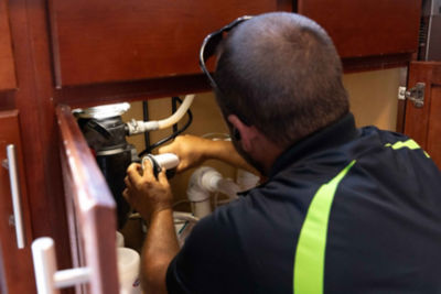 plumber making repair under sink