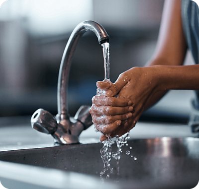Washing hands in kitchen sink faucet