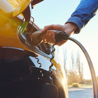 Man charging yellow electric car