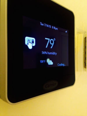 Smart thermostat on wall showing 79 degrees