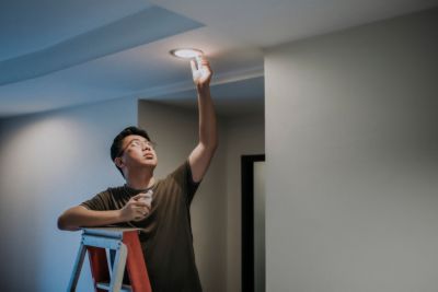 homeowner replacing their recessed lighting bulb