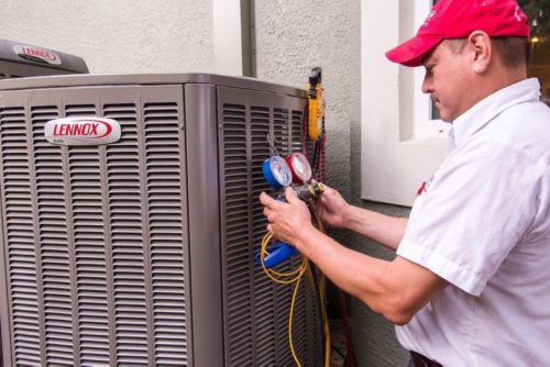 Red Cap Plumbing & Air tech repairing a Lennox heat pump unit