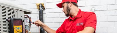 A Red Cap technician checking an exterior electrical system