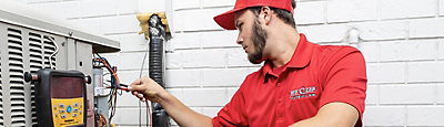 A Red Cap technician checking an exterior electrical system