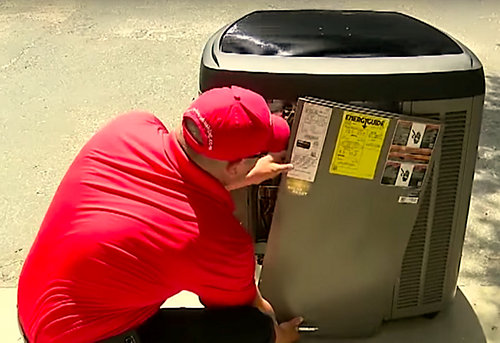 a person in a red shirt looking at a refrigerator suggested