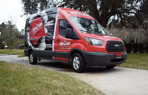 A Red Cap branded service vehicle parked in a paved driveway