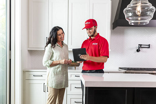 A Red Cap technician and a customer discussing a service