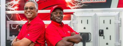 Two Red Cap employees in red shirt with arms crossed