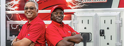 Two Red Cap employees in red shirt with arms crossed