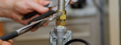 Closeup of someone working on a gas line with wrenches