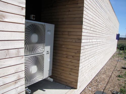 Heat Pumps on the back of a wood house 