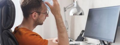 A person sitting at a desk with a bottle of water on his head