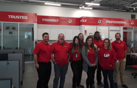 Red Cap employees standing outside, in front of their office