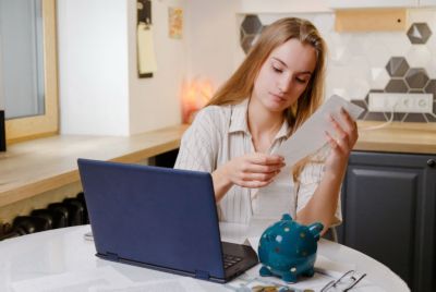 A Person Looking at a Paper and a Laptop