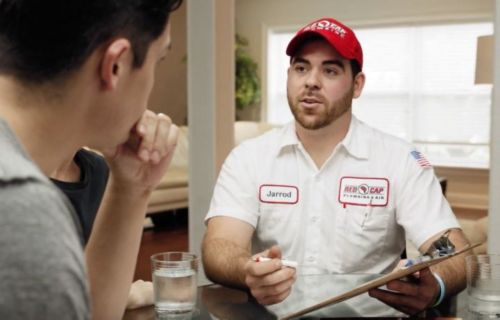 Red Cap AC technician explaining a system check to a homeowner