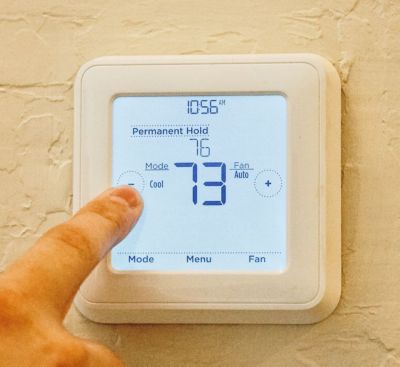 A finger pressing a screen on a wall