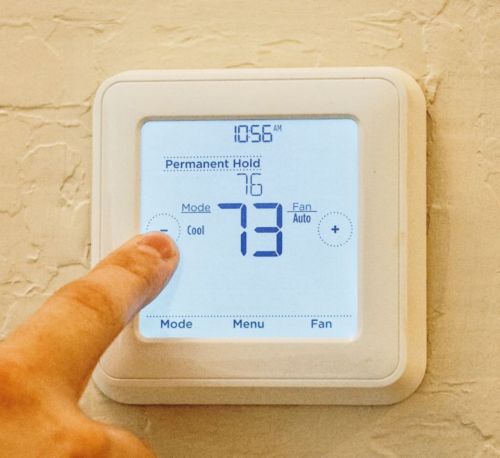 A finger pressing a screen on a wall