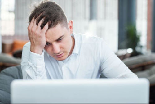 A person in a white shirt looking at a computer screen