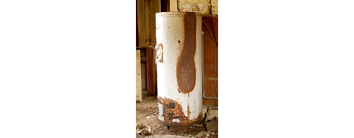 A white metal cylinder with rust on it