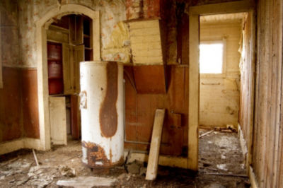 Rusted out water heater in old delapidated house
