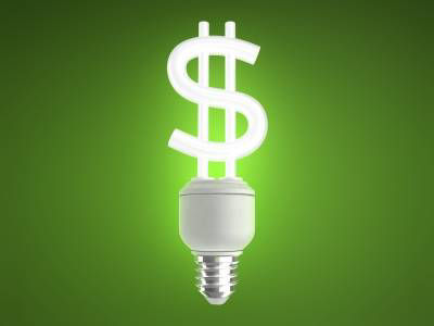 Lightbulb in shape of dollar sign on green background