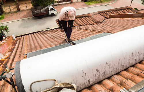 A person using a tool to fix a roof