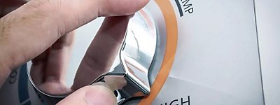 Hand adjusting the temperature water heater - Williams Comfort Air Heating, Cooling, Plumbing & More