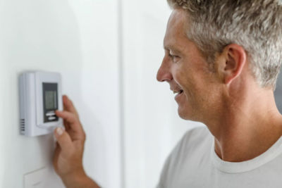 Image of a man setting a thermostat