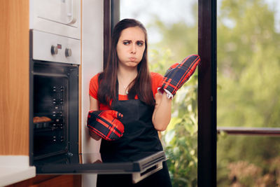 Woman standing in front of an oven 