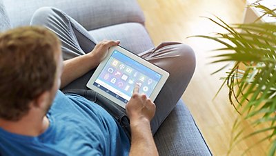 Many sitting cross legged with tablet in lap