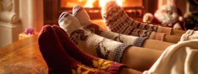 Closeup photo of family feet in woolen socks lying next to fireplace