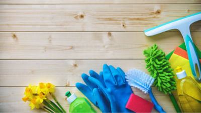 Colorful cleaning supplies on wood surface