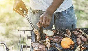 Man grilling a bunch of food outside on grill