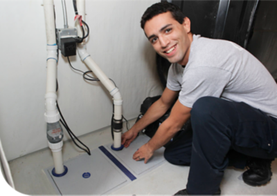 Technician smiling in front of a sump pump